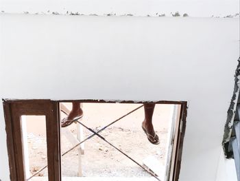 Low section of people on wooden post against sky