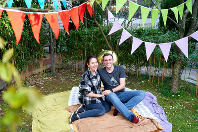 Portrait of young man sitting against plants
