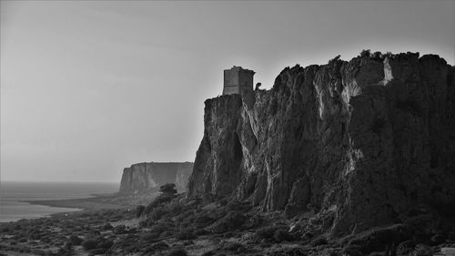 Rock formations by sea against sky