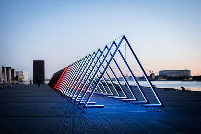 Bridge over river against buildings in city against clear sky