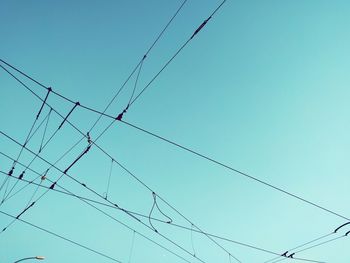 Low angle view of power lines against blue sky