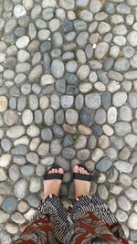 Low section of woman standing on footpath