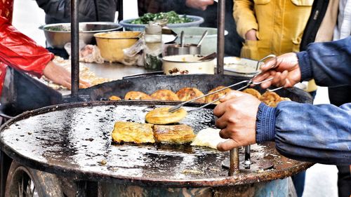 Close-up of man preparing food on barbecue grill