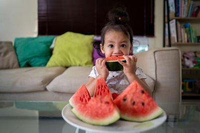 Portrait of boy holding watermelon at home
