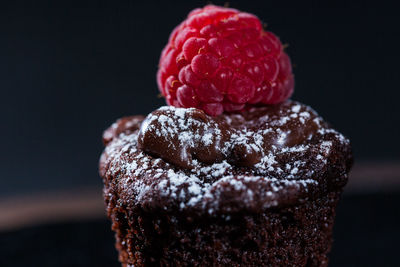 Close-up of strawberry cake against black background