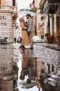 Man standing on wet street in rain