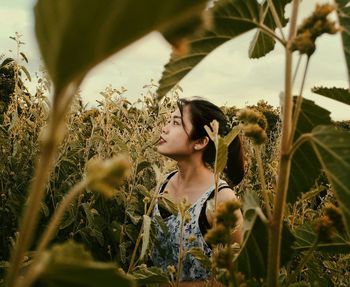 Close-up of young woman against plants