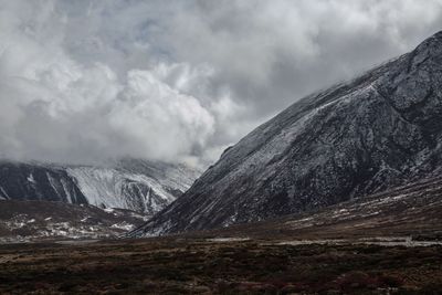 Scenic view of mountains against cloudy sky