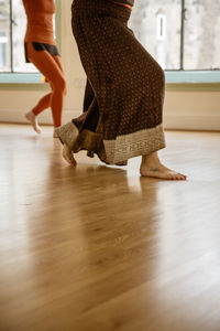 Low section of woman dancing on hardwood floor