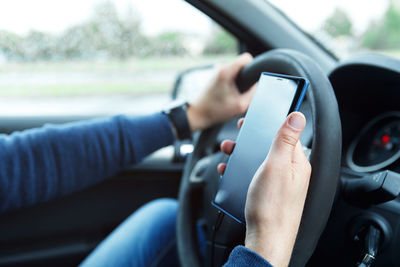 Cropped hand of man driving car