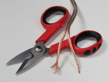 High angle view of electric cables and scissors on gray background