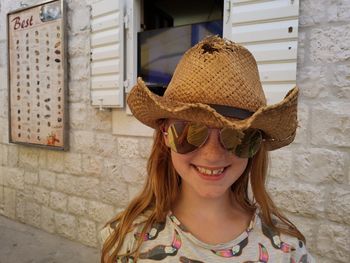 Portrait of smiling girl against wall