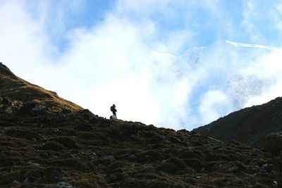 Low angle view of mountain against cloudy sky