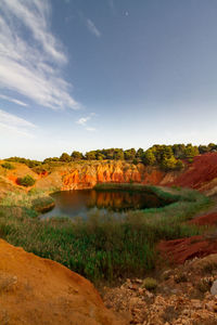 Green lake over an old bauxite mine with orange ground