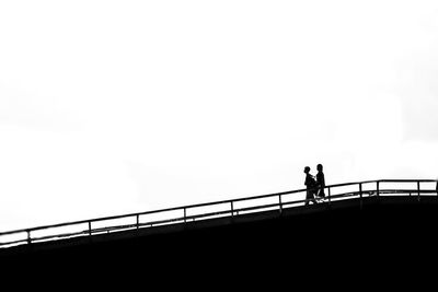 People walking on bridge against sky