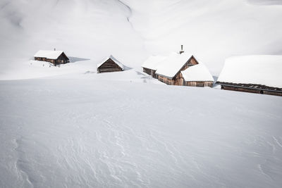Scenic view of snow covered houses by land