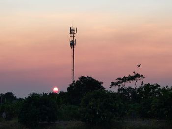 Low angle view of communications tower against sky during sunset