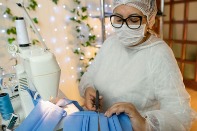 Mature woman making mask at workshop