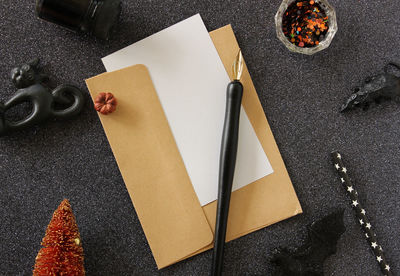 Directly above shot of fountain pen on paper with envelope at table during halloween