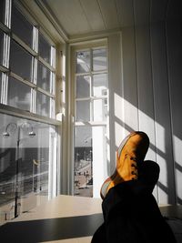 Rear view of woman standing by window