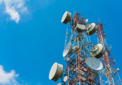 Low angle view of communications tower against blue sky