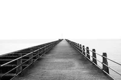 Pier over sea against clear sky