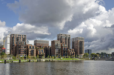 Recently completed little c neighbourhood and adjacent park under a sky with dramatic clouds