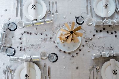 High angle view of plates with forks and containers on table