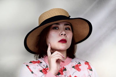 Portrait of woman wearing hat against wall