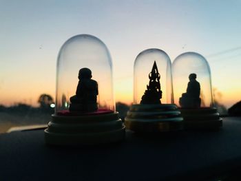 Silhouette figurines against sky during sunset