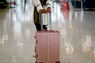 Low section of person walking on floor at airport