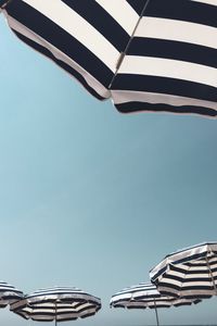 Low angle view of beach umbrellas against clear sky