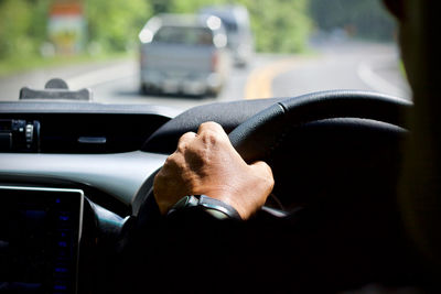 Cropped hand of man driving car