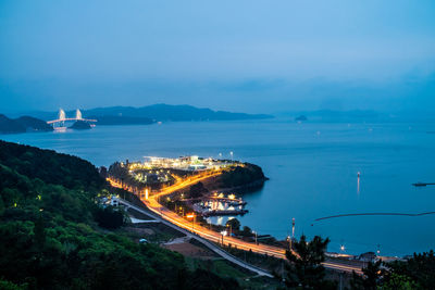 High angle view of city by sea against sky