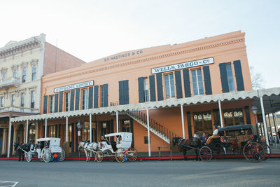 People on street against buildings in city