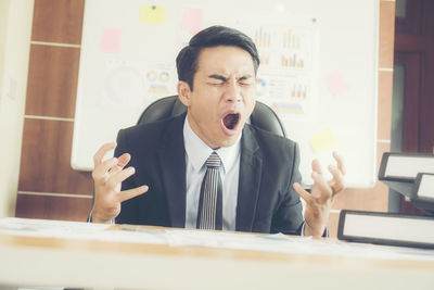 Frustrated businessman man sitting on chair at office