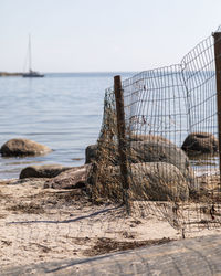 Fence on beach against clear sky