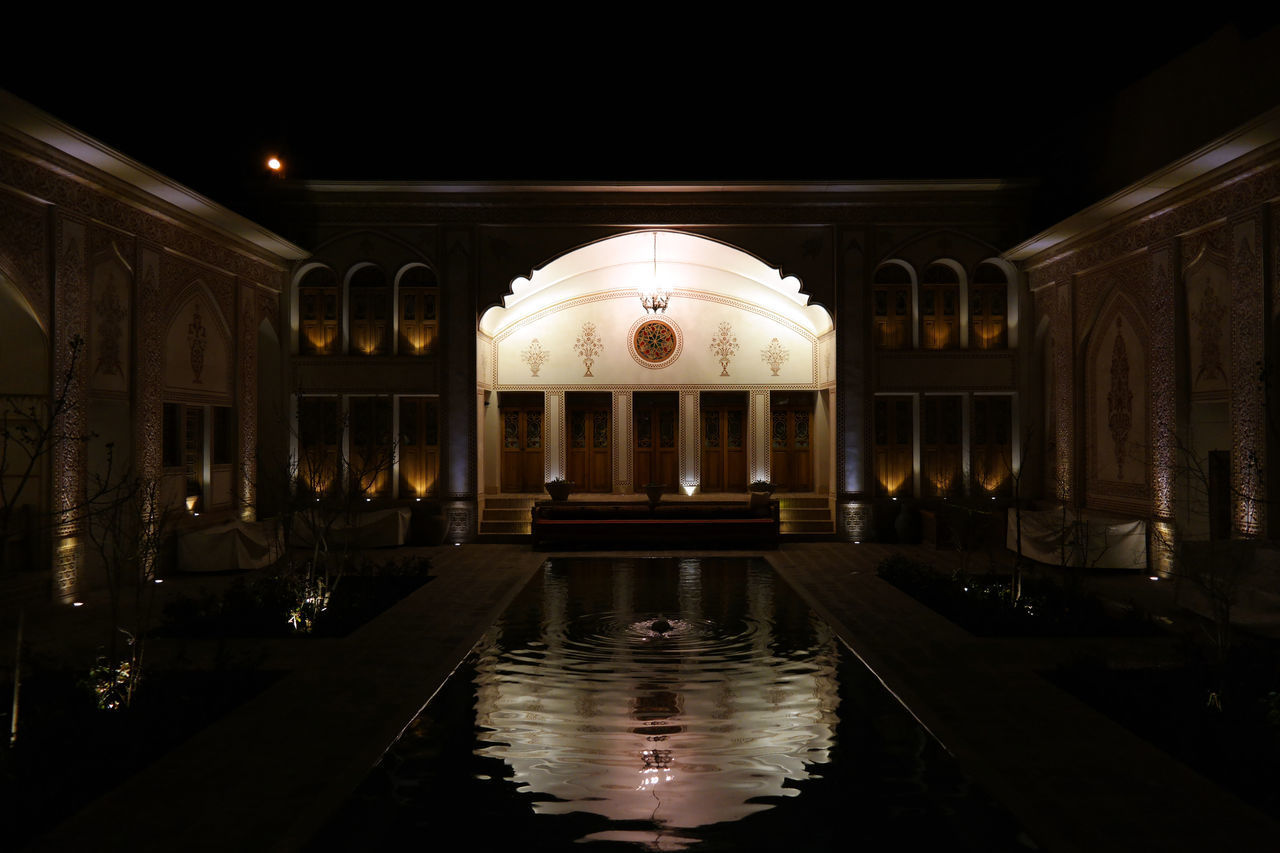 REFLECTION OF ILLUMINATED BUILDING IN WATER