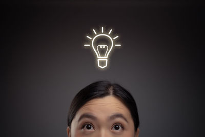 Close-up portrait of illuminated lamp against black background