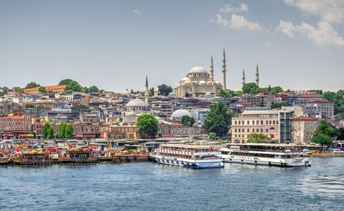 Scenic view of river by buildings against sky in city