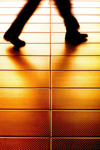 Low section of people walking on tiled floor