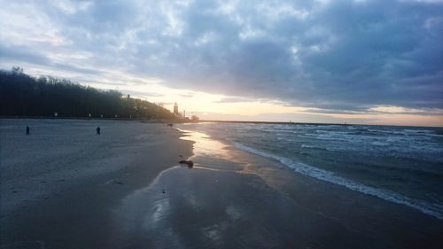 Scenic view of beach against dramatic sky