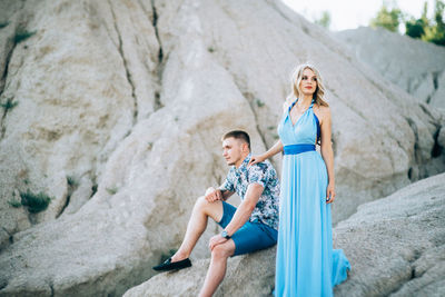 Full length of woman sitting on rock