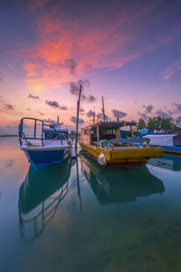 Boats moored in sea during sunset