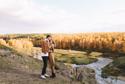 Happy people in love are travel hike in nature in the autumn forest. romantic trip to countryside