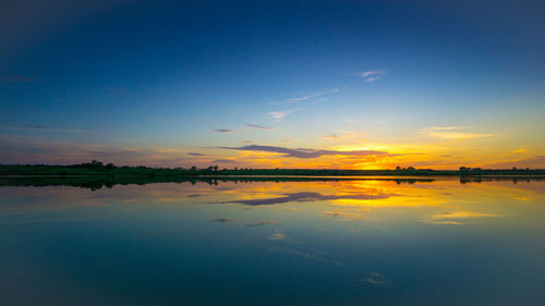 Reflection of clouds in sea at sunset