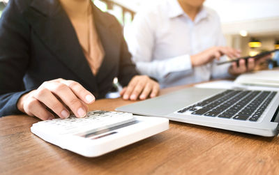 Midsection of woman using laptop on table