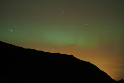 Low angle view of silhouette mountain against sky at night