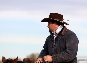Man standing in traditional windmill against sky