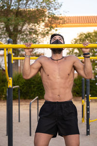 Full length of shirtless man standing outdoors